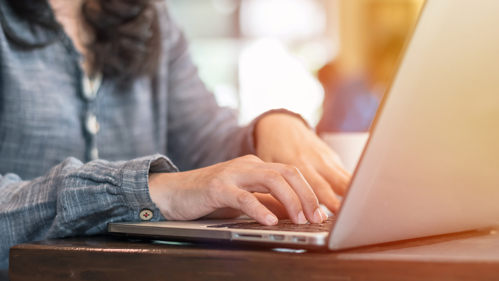 close up of young woman's hands on laptop